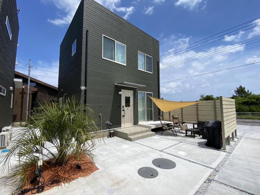 a black house with a tent on a patio at Pleasure Point Ichinomiya in Ichinomiya