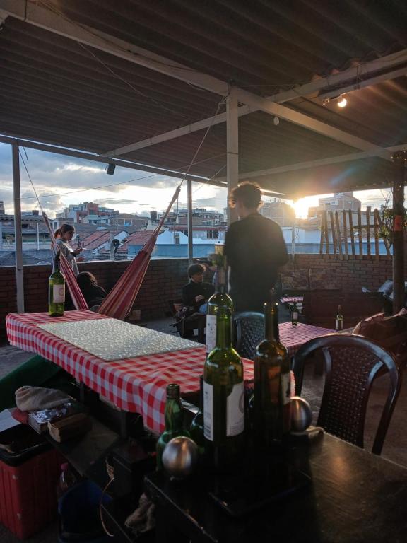 un hombre de pie en una mesa con botellas de vino en ella en Renacer casa studio, en Sogamoso