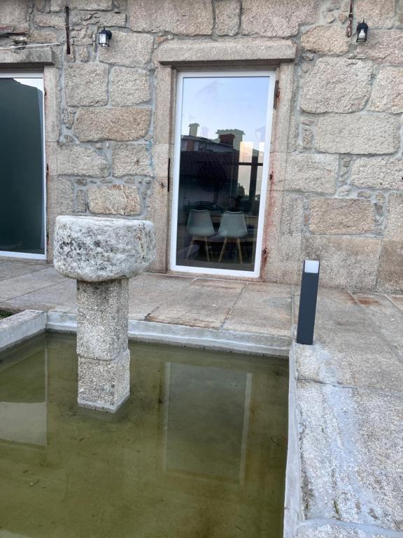un edificio con una piscina d'acqua di fronte a una finestra di Quinta Lourenca - Vila do Conde a Vilar