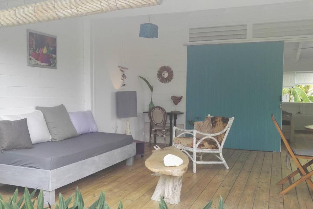 a living room with a couch and a table at LE SUNSET gîte côté canne in Grand-Bourg