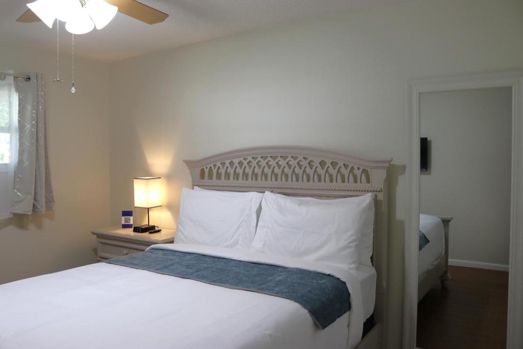 a bedroom with a bed with white sheets and pillows at Hidden Sapphire-Apartment with Kitchen and Laundry in Lakeland