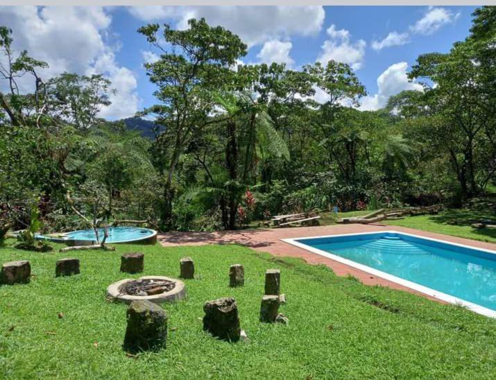 a resort with a swimming pool and a yard with trees at Tipis Cuetzalan in Cuetzalán del Progreso