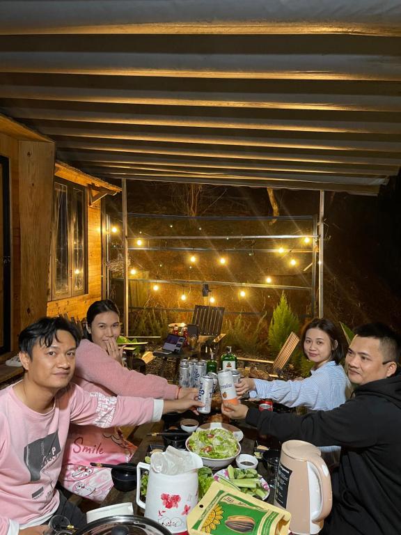 a group of people sitting at a table eating food at Lâm Bích Homestay & Coffee in Ấp Phước Thánh