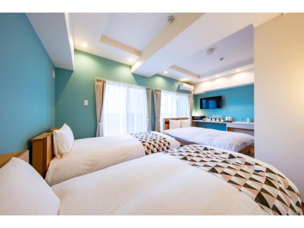 札幌的住宿－VILLA KOSHIDO KOTONI - Vacation STAY 49590v，蓝色墙壁客房的两张床
