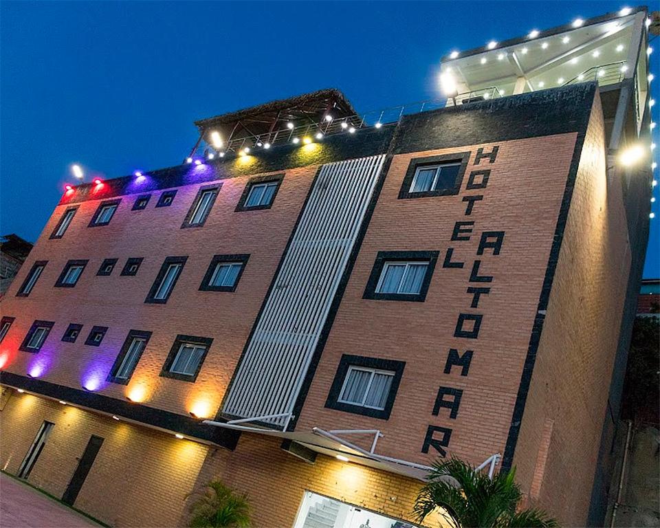 un edificio de ladrillo alto con luces encima en Hotel Alto Mar, en Catia La Mar