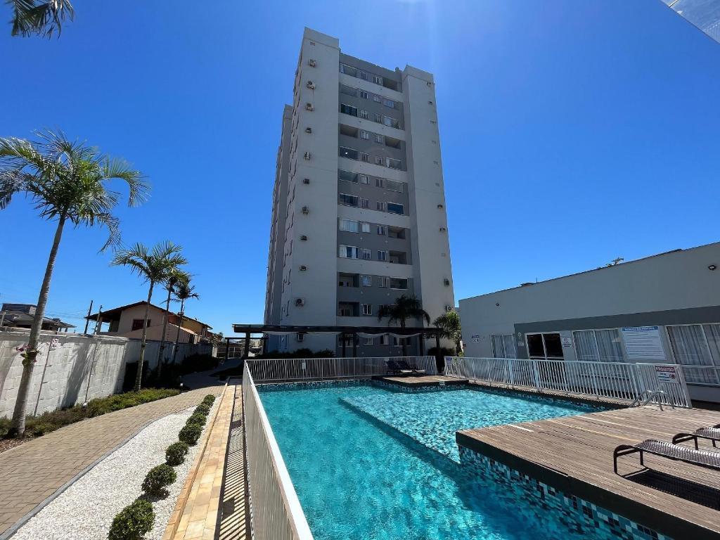 basen przed wysokim budynkiem w obiekcie Apartamento Completo perto da Praia e Beto Carrero World! w mieście Balneário Piçarras