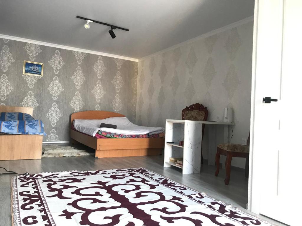 a bedroom with a bed and a rug at Cottage town D&N in Karakol