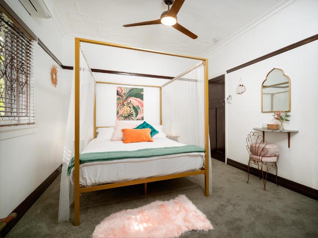 a bedroom with a canopy bed with orange pillows at Anville Court in Brisbane