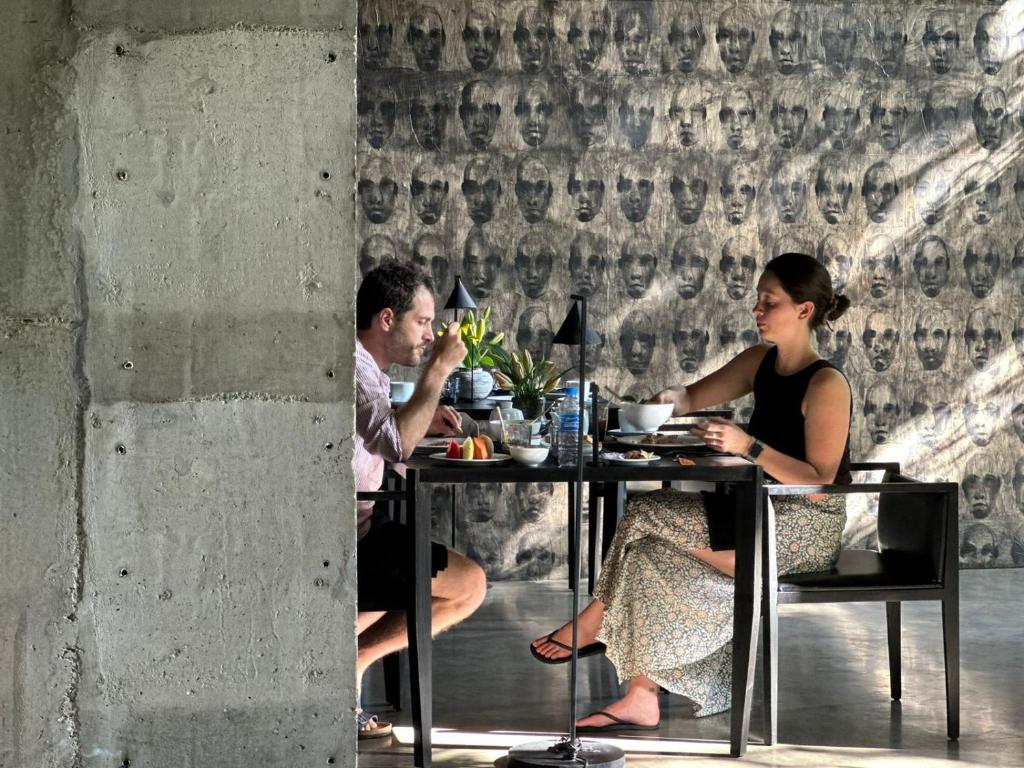 een man en een vrouw aan een tafel bij Saffron Robes Living in Hikkaduwa