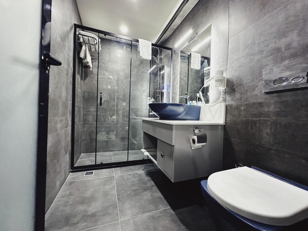 y baño con ducha, aseo y lavamanos. en Kadıköy Duck hotel, en Estambul