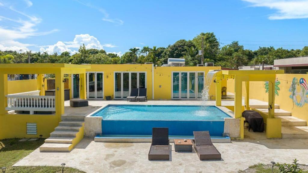 una casa amarilla con una piscina frente a ella en Casa De Sol Family Home Near Rincon & Beach en Aguada