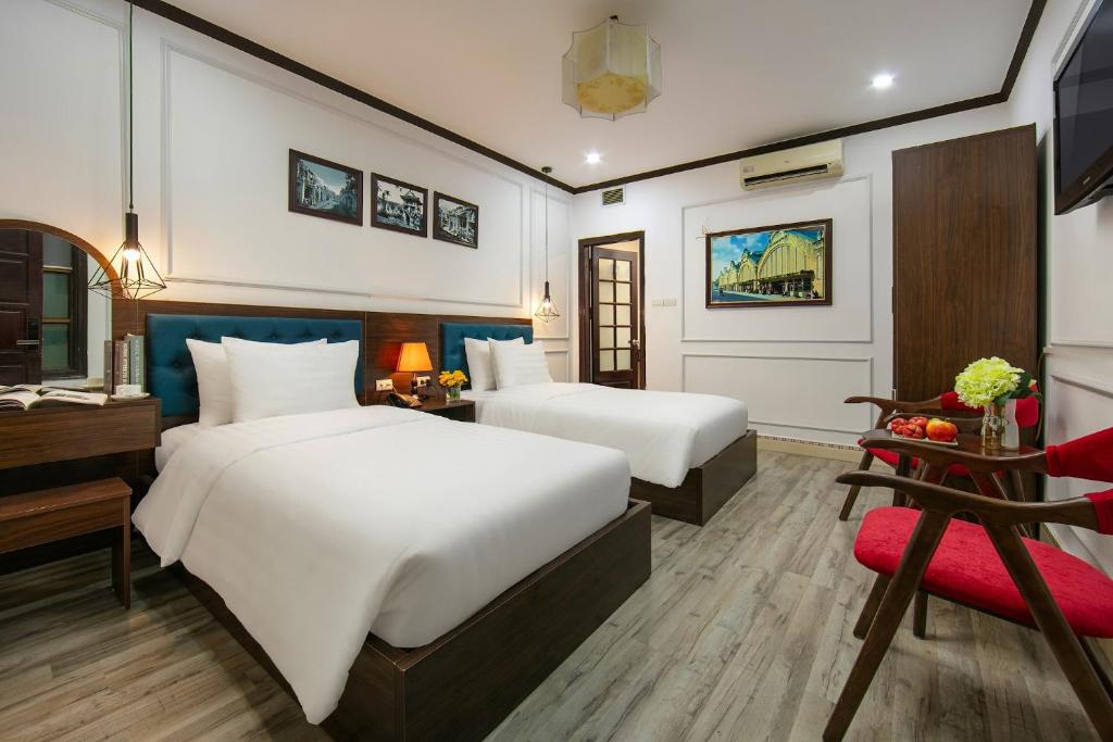 Postel nebo postele na pokoji v ubytování Silk Hanoi Moment Hotel & Spa - Hanoi Old Quarter