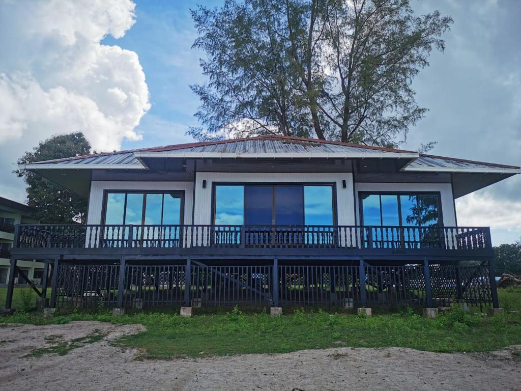 Century Langkasuka Resort Langkawi في بانتايْ سينانج: منزل مع شرفة كبيرة وسقف