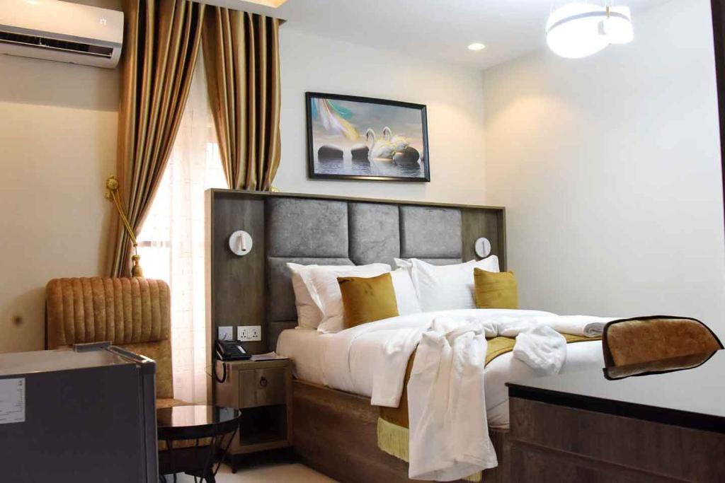 a hotel room with a large bed and a desk at Castle Estate Apartments 3 in Abuja