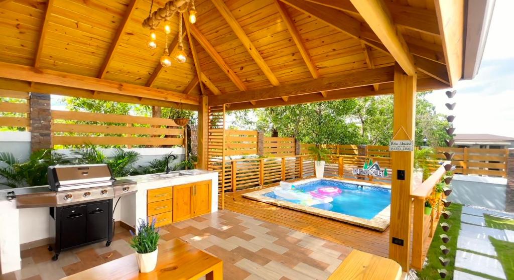a patio with a kitchen and a swimming pool at The Grand Chalet in Jarabacoa