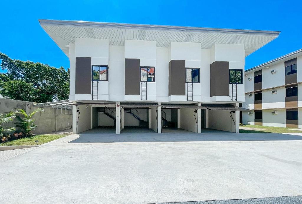 un gran edificio blanco con ventanas en un aparcamiento en RedDoorz @ Washington Guest House Olongapo en Olongapo