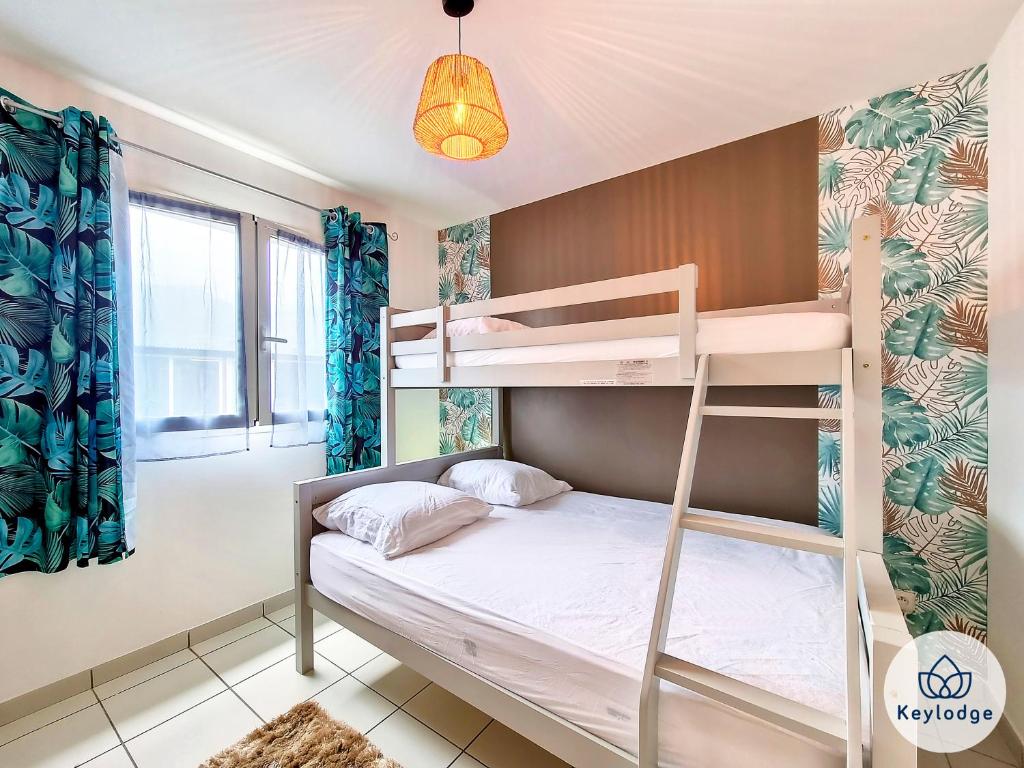 a bedroom with a bunk bed with a ladder at Villa Ti Coin Frais - 100 m² - Plaine des Palmistes in La Plaine des Palmistes