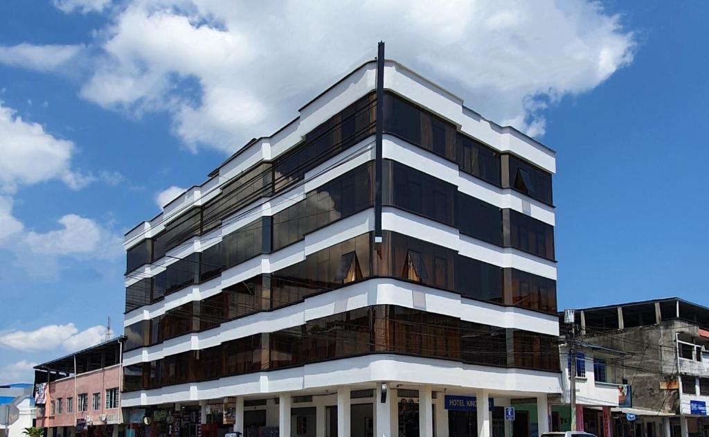 un edificio alto en blanco y negro en una calle de la ciudad en Hotel King David Ecuador, en Nueva Loja