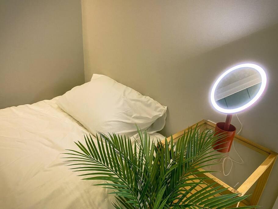 sypialnia z łóżkiem z lustrem i rośliną w obiekcie Stay Light w Seulu