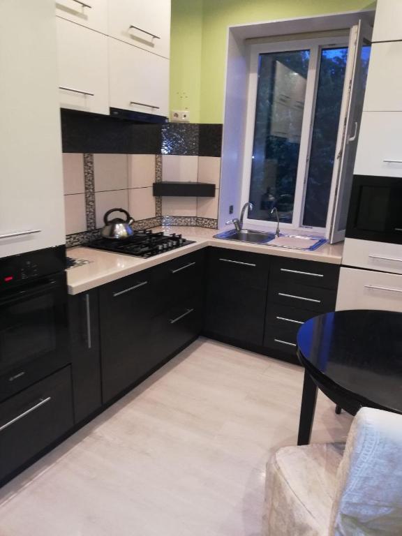 a kitchen with black and white appliances and a table at City Centre Vip 218 in Tbilisi City