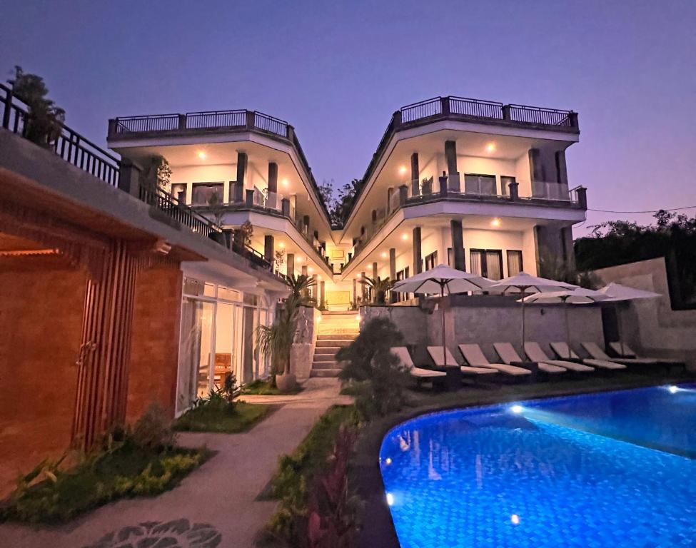 une grande maison avec une piscine en face de celle-ci dans l'établissement Grand Yuna Hotel Nusa Penida, à Toyapakeh