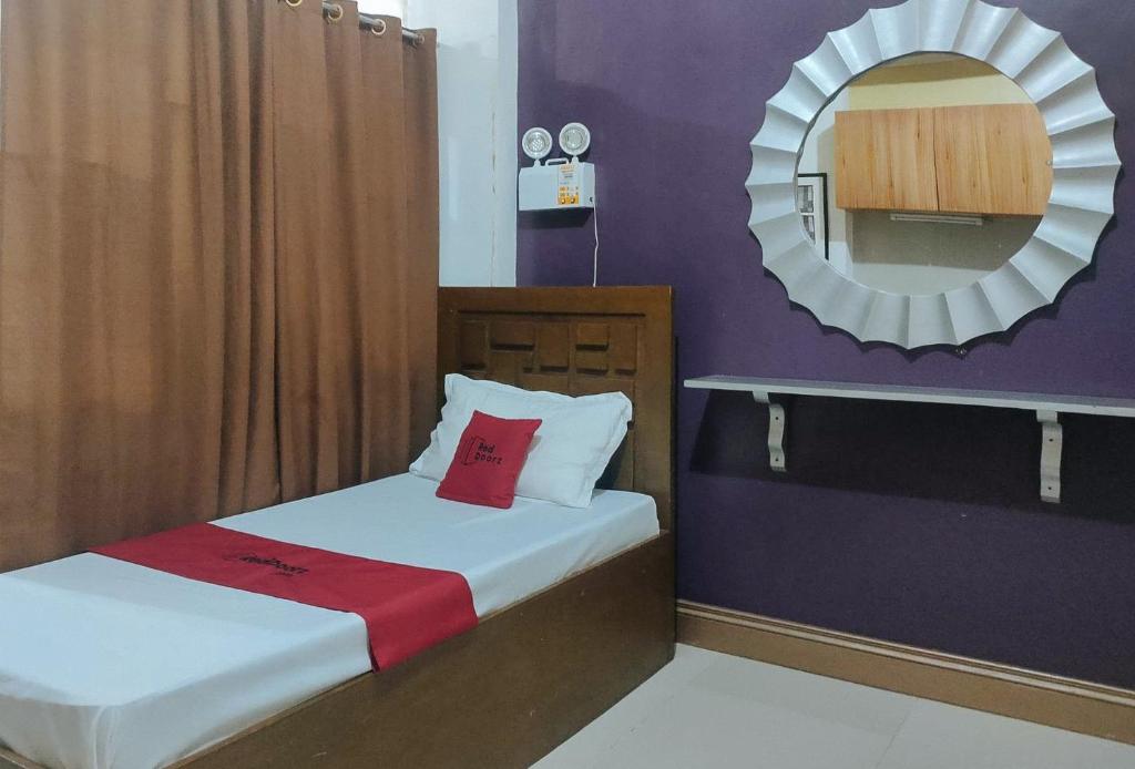 ein kleines Zimmer mit 2 Betten und einem Spiegel in der Unterkunft RedDoorz near Colgante Bridge Naga City in Naga
