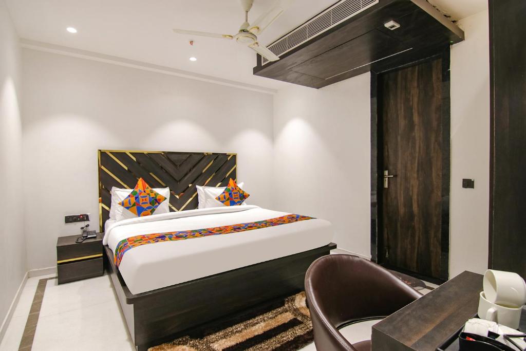 una camera con un grande letto e una sedia di FabHotel Greysky a Nuova Delhi