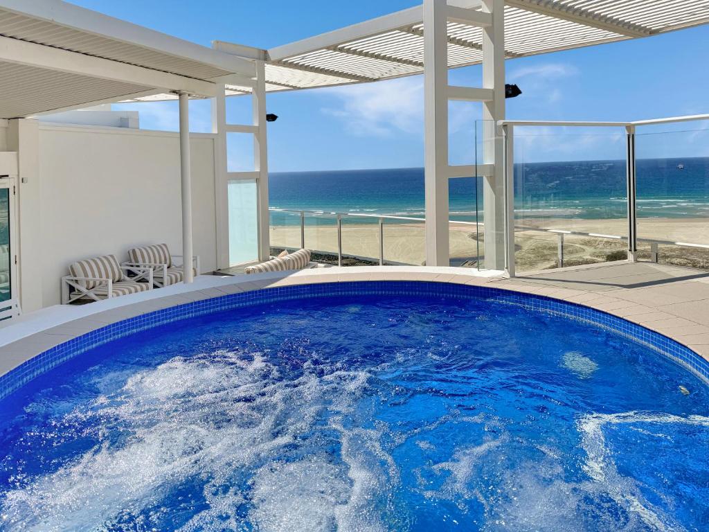 a swimming pool with a view of the ocean at Kirra Penthouse with Private Spa in Gold Coast