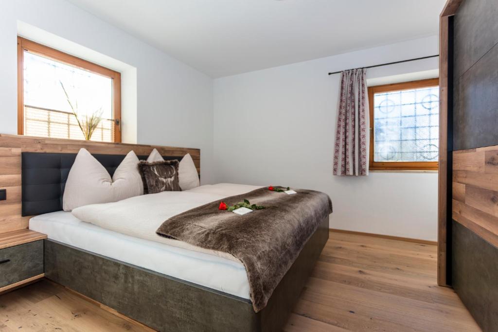 1 dormitorio con 1 cama grande con sábanas blancas en STOAMAT Appartements en Lofer
