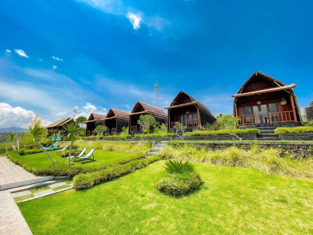 szereg domków z zielonym trawnikiem w obiekcie Pinggan caldera w mieście Baturaja