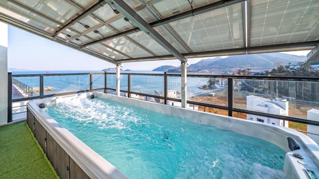 a hot tub on the balcony of a building at Geoje Highend Spa Pension in Geoje 