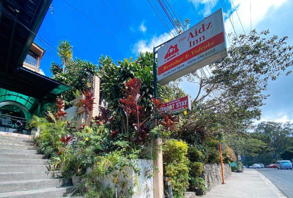a sign for a hotel on the side of a street at RedDoorz Hostel @ Tita Aidz Inn Baguio in Baguio