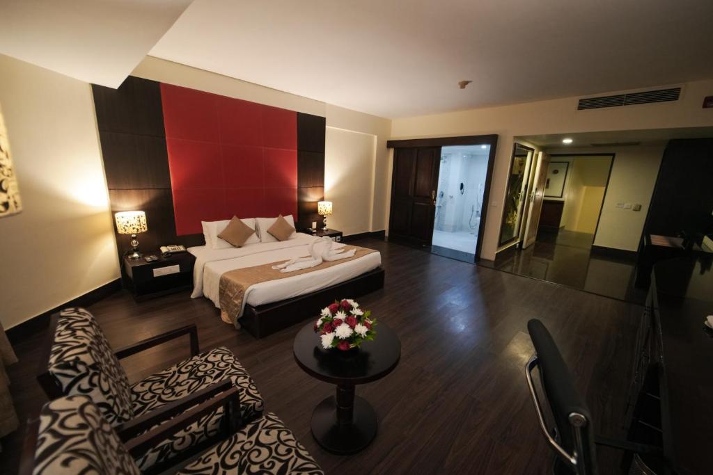 um quarto de hotel com uma cama e uma sala de estar em The South Park Hotel em Trivandrum