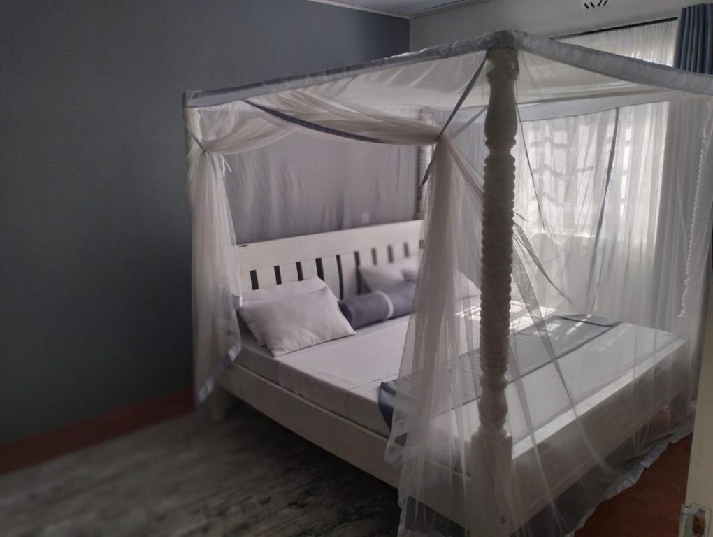 a bed with a canopy in a room at Casa Nostra funyula in Nangina