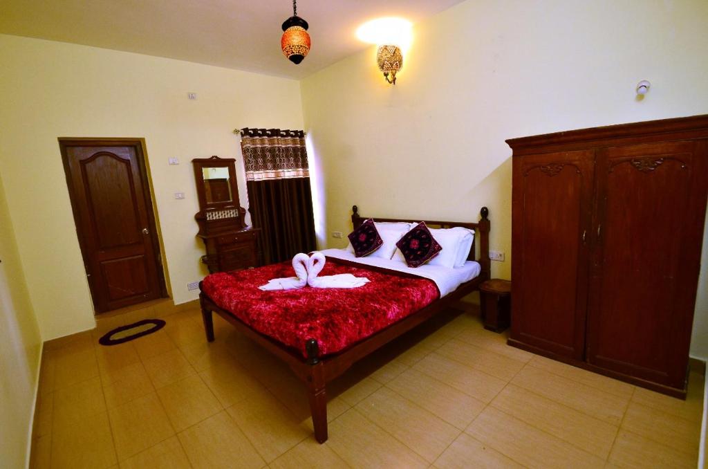 sypialnia z łóżkiem z czerwonym kocem w obiekcie Al Safa Home Stay Un -Married And Stag Groups Not Allowed w mieście Utakamand
