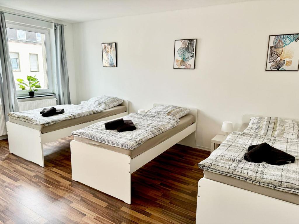 two beds in a white room with wooden floors at Beautiful Apartment in Düren in Düren - Eifel