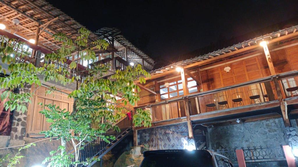 a building with a tree in front of it at Omah Singo Stay and Resto in Bantul