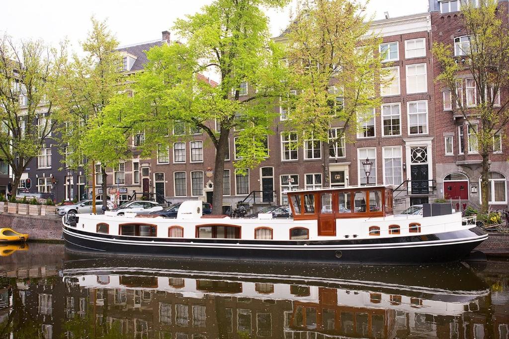 a boat on a river in front of buildings at Prinsenboot in Amsterdam