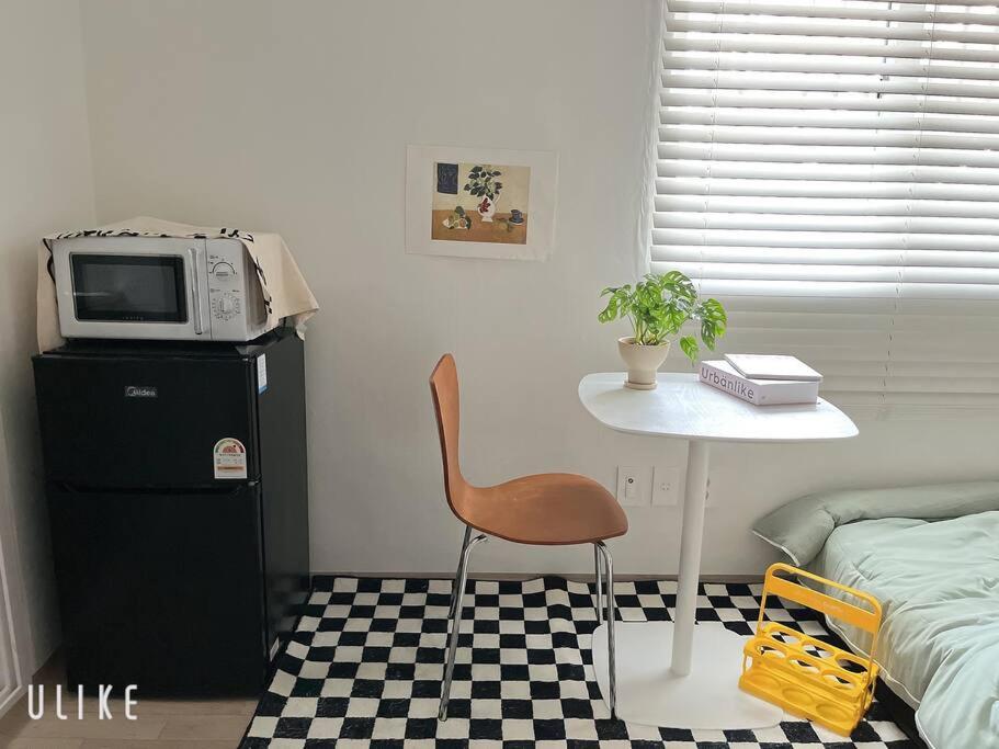 a room with a table and a chair and a microwave at Tolerance in Incheon