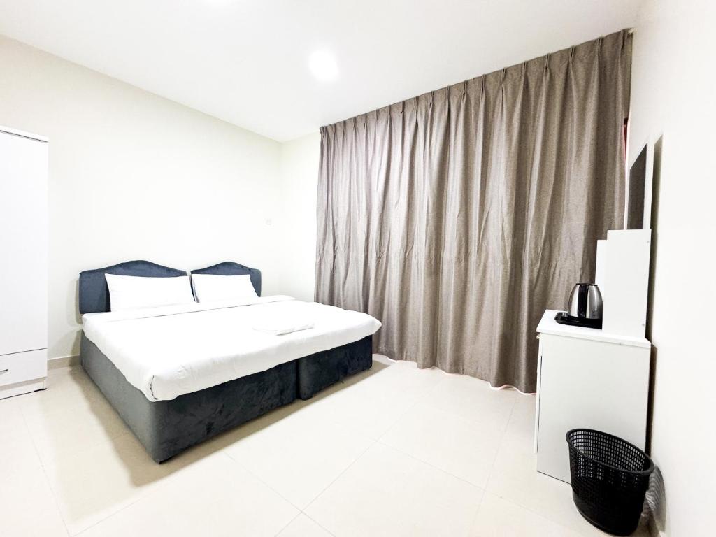 a white bedroom with a bed and a window at Ras Star Residence - Home Stay in Dubai