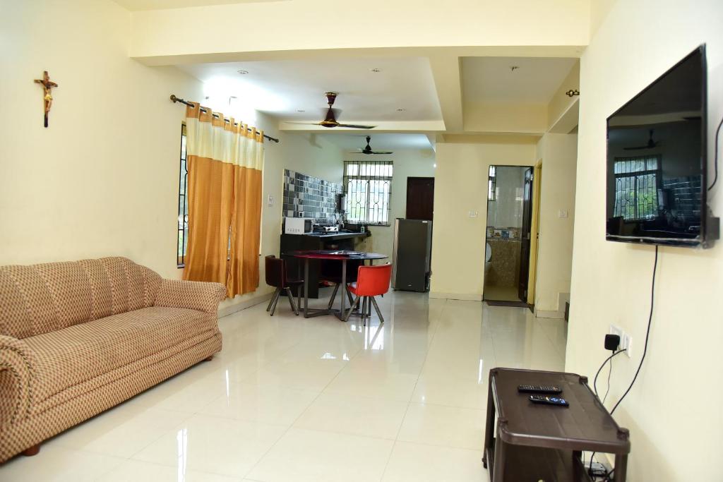 uma sala de estar com um sofá e uma televisão em Field Stone -3 BHK duplex villa em Talaulim