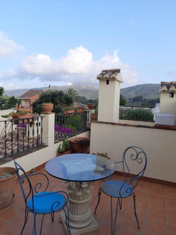 a patio with a table and chairs on a balcony at Casa Rosa in Alcalalí