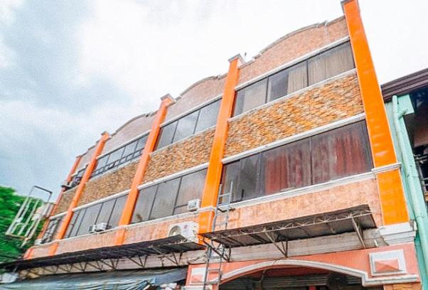 a tall brick building with windows on the side of it at RedDoorz @ PVC Pension Haus in Tagum