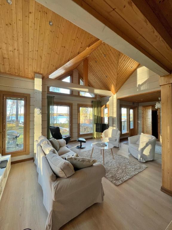 Elle comprend un salon doté d&#39;un mobilier blanc et de plafonds en bois. dans l&#39;établissement Saimaan Villa Mustikka, à Äitsaari