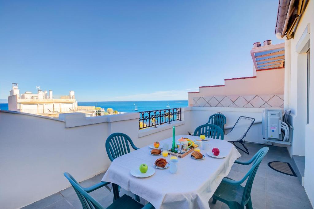 - une table sur un balcon avec vue sur l'océan dans l'établissement Le 44 Antibes - Sea & Mountain View - Happy Rentals, à Antibes