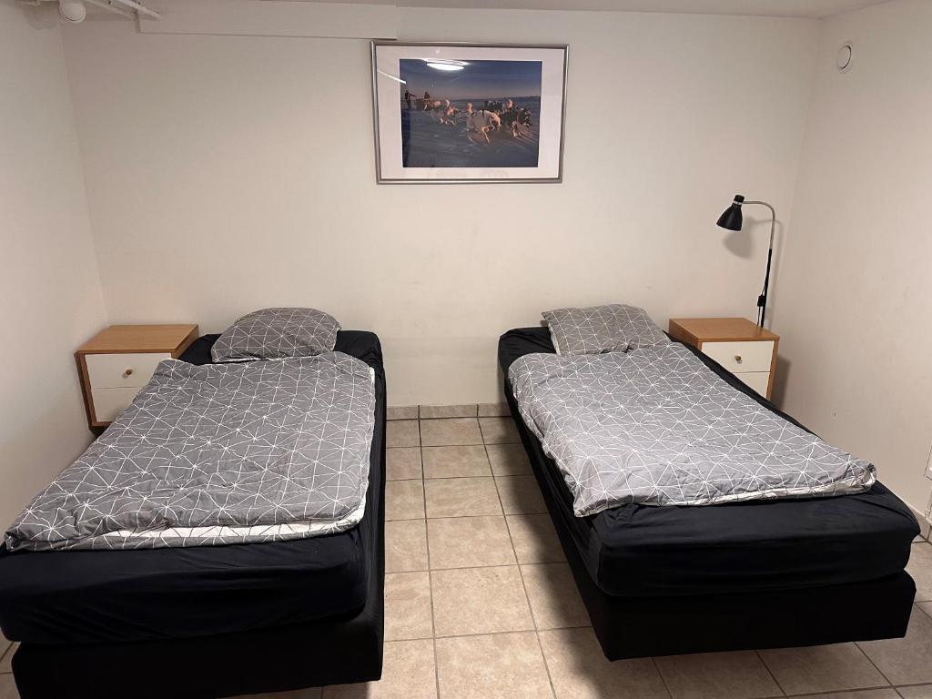 a room with two beds in a room with a picture at Nice apartment in Odense in Odense