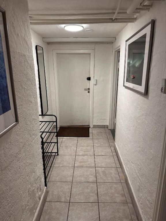 a hallway with a white door and a tile floor at Nice apartment in Odense in Odense