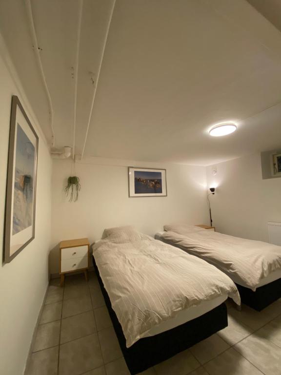 a bedroom with two beds and a lamp on the wall at Nice apartment in Odense in Odense