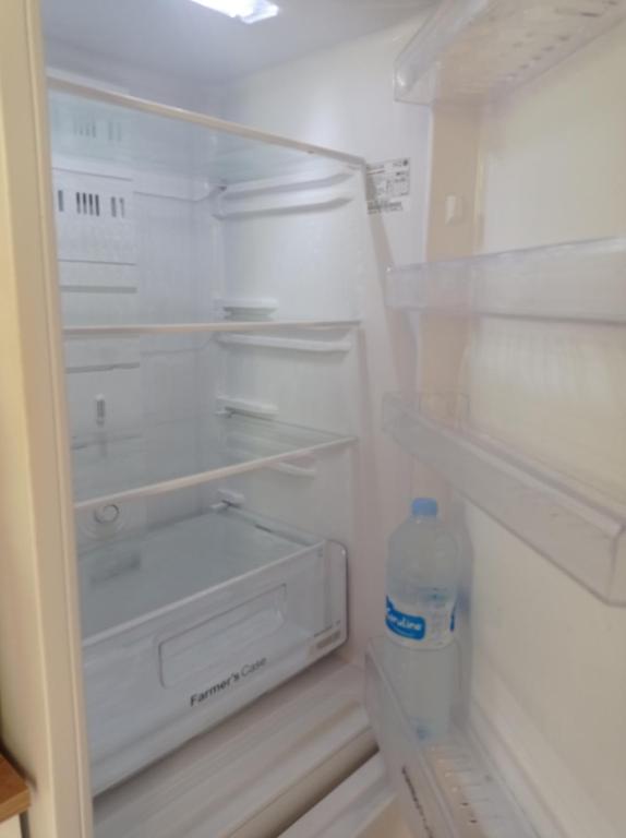 einem leeren Kühlschrank mit einer Flasche Wasser in der Unterkunft Villa Caracas in Lamentin