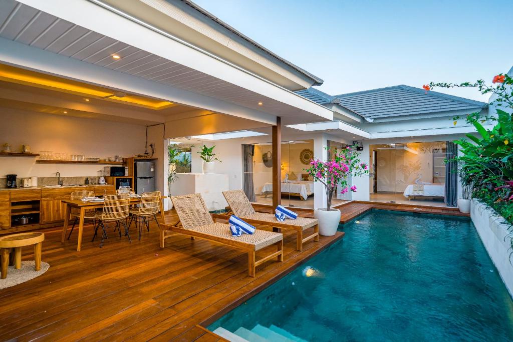Una piscina en una casa con cocina y comedor en Villa Ryky 2-bedroom private luxury villa in Nyanyi Beach, en Tanah Lot